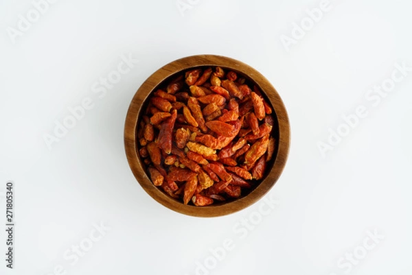 Obraz Dried bird's eye chili peppers in a wooden bowl. White background, high resolution