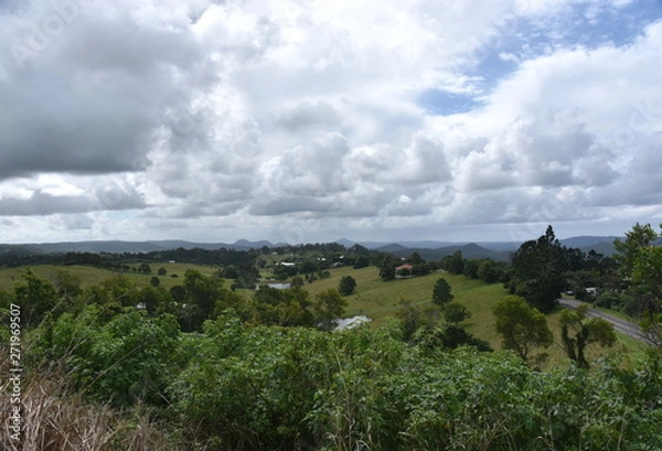 Fototapeta Broad panorama of the countryside on Sunshine Coast Hinterland. Grassy hills in the background. View from Kanyana Park on a cloudy day (Queensland, Australia).