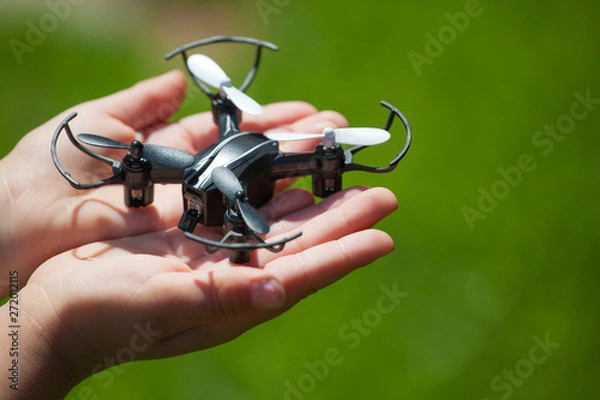 Obraz quadcopter children hand grass background 