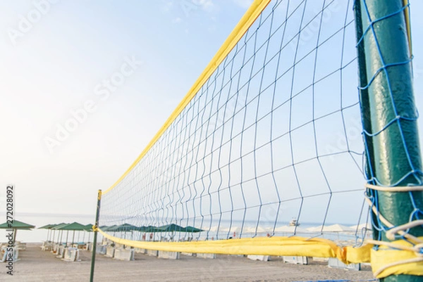 Fototapeta A volleyball net on the beach with a clear and sunny sky