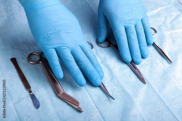 Obraz Detail shot of sterilized surgery instruments with a hand grabbing a tool ,