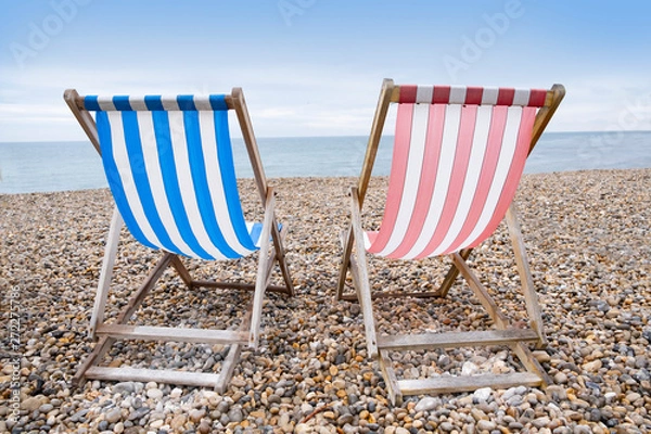 Obraz Deckchairs on beach, typical english seaside holiday scene, red and blue stripes representing main political party of labour or conservative