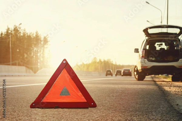 Fototapeta Broken car on the side of the highway and an emergency stop sign