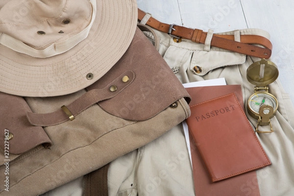 Fototapeta Prepare for journey in safari style, hiking and backpacker - accessories and travel items, packing clothes in backpack: backpack, passport, tickets, hat