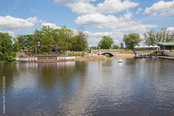 Fototapeta City Jelgava, Latvian Republic. River Lielupe, peoples and urban city view. Houses and walking paths. Jun 9. 2019.