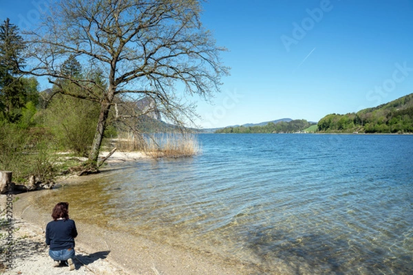 Obraz Junge Frau kniet am Ufer eines Sees