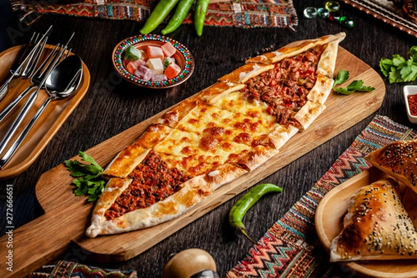 Obraz Traditional Turkish cuisine. Turkish pizza Pita with a different stuffing, meat, cheese, slices of veal. Turk Pidesi or Sucuk Pide. Serving dishes in the restaurant. Copy space