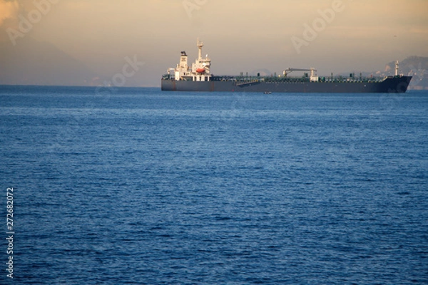 Fototapeta View of the huge sea liner in the harbor on the background of the sunset on the sea