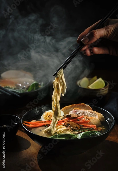 Obraz Ręka z pałeczkami bierze makaron zupy ramen. Tradycyjna kuchnia azjatycka