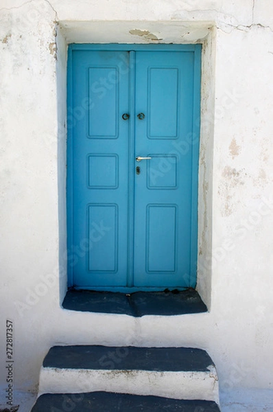 Fototapeta Beautiful picturesque turquoise blue wooden door and white wall. Entrance. Mediterranean motif.