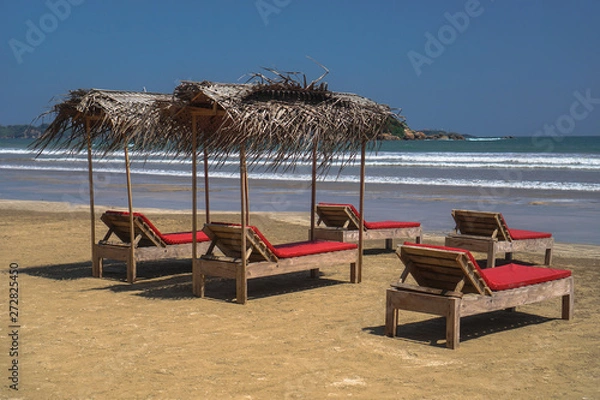 Fototapeta Beautiful Sri Lankan view of the Indian Ocean with sun loungers on the beach. Summer holidays in Asia. Stock photos