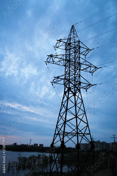 Fototapeta power line tower on the lake against the sky