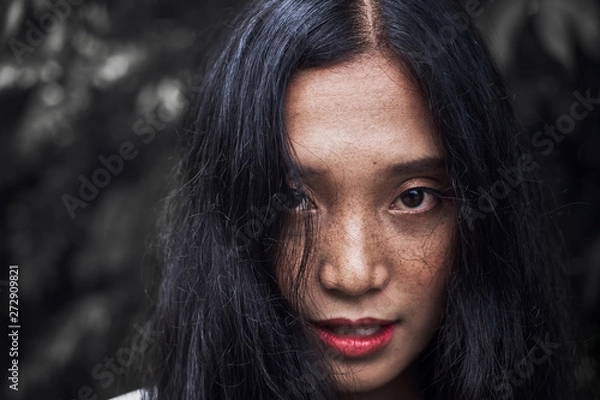 Fototapeta Close-up photos of a woman face with freckles The eyes look uncompromising.