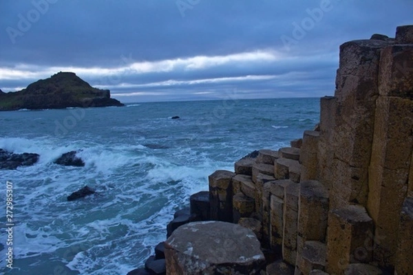 Fototapeta View of the Rocks of Giants Causeway with sea sprayed rocks and Ocean behind