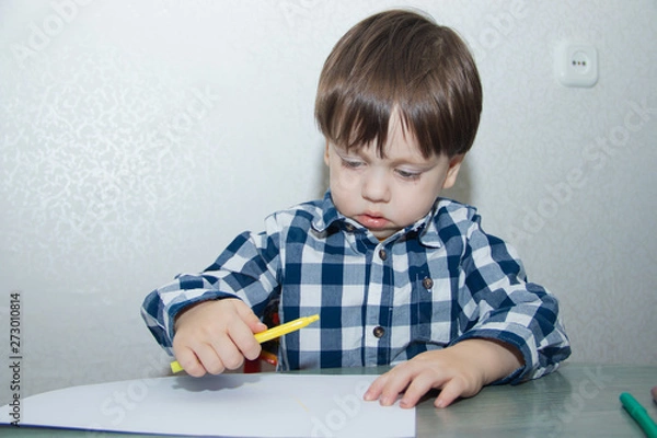 Fototapeta The boy draws felt-tip pens on paper. Drawing. Little boy. Children's drawing. Developmental activities.