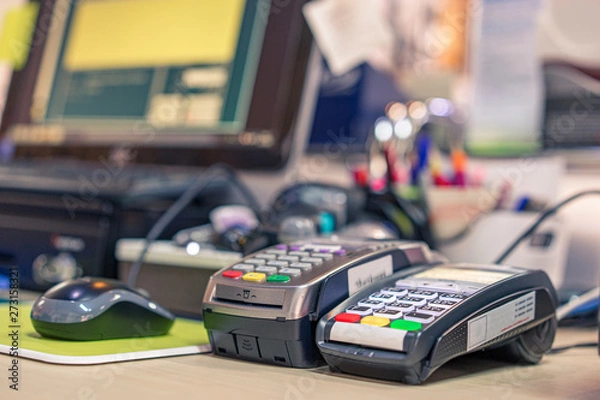 Fototapeta Credit card reader machine on cashier desk in department store  with selective focus effect