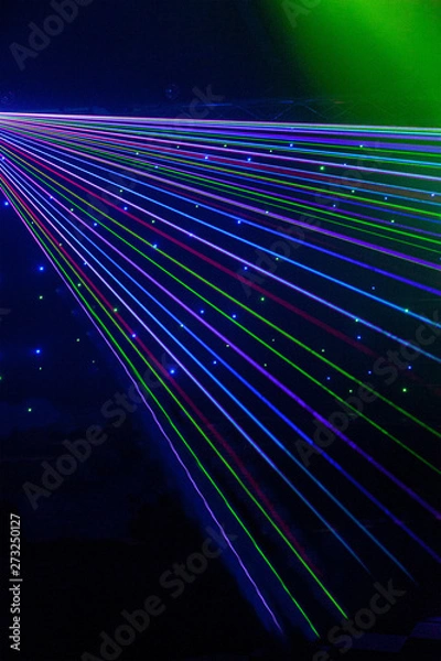 Fototapeta Bright nightclub red, green, purple, white, pink, blue laser lights cutting through smoke machine smoke making light patterns on the dance floor with bokeh in the background. Mardi Gras inspiration