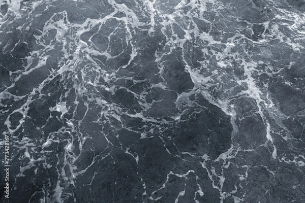 Fototapeta Dark water of stormy sea and white foam. Horizontal color photography.