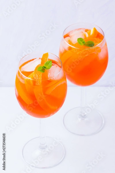 Fototapeta Aperol Spritz cocktail with mint leaves on a white background. Italian cocktail aperol spritz on white. Isolated