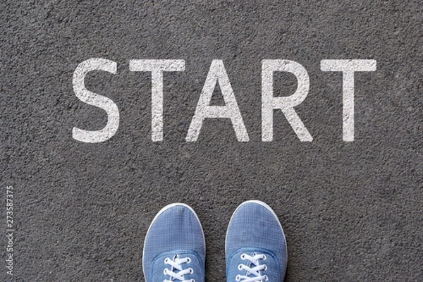Obraz Pair of feet on tarmac road with print of word start for concept of starting point.