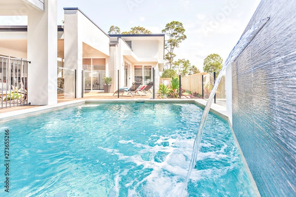 Fototapeta Swimming pool design with water and house garden.