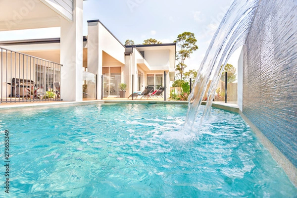 Fototapeta Swimming pool in house front side near garden.