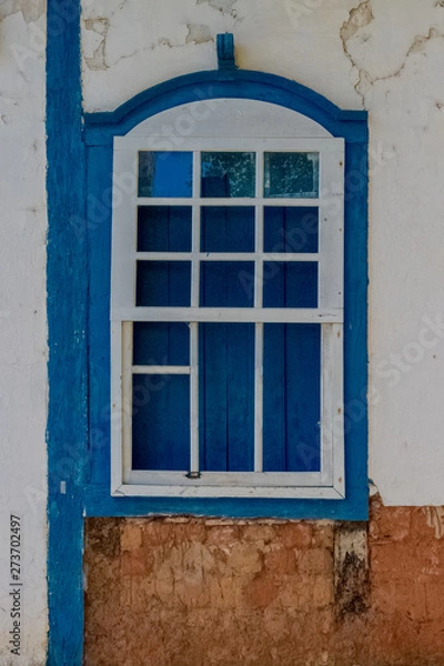Fototapeta Colonial withe window with blue frame, made of wood of the Pirenopolis