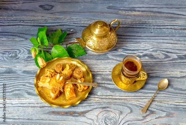 Fototapeta Eastern sweets "baklavadakia" and a cup of coffee on a wooden background