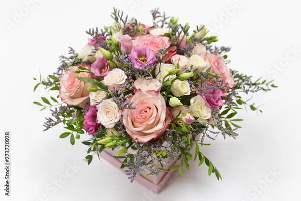 Fototapeta delicate floral arrangement of roses and live decorations in a square cardboard box (primary color - pink) on a light background