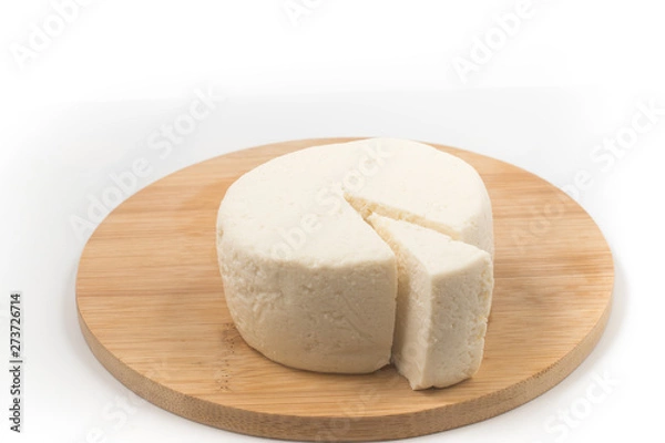 Fototapeta Slice of Ricotta Cheese over a wooden board