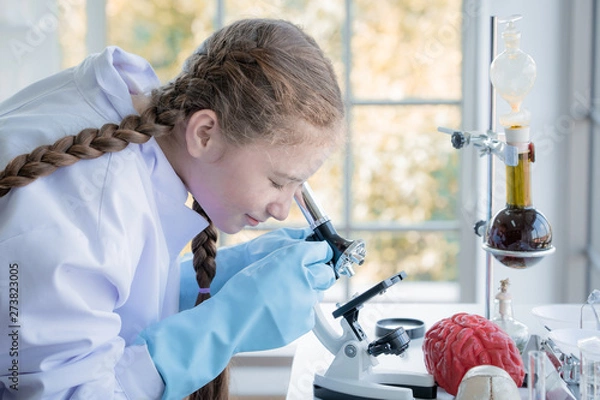 Fototapeta girl in high school students using microscopes in laboratory