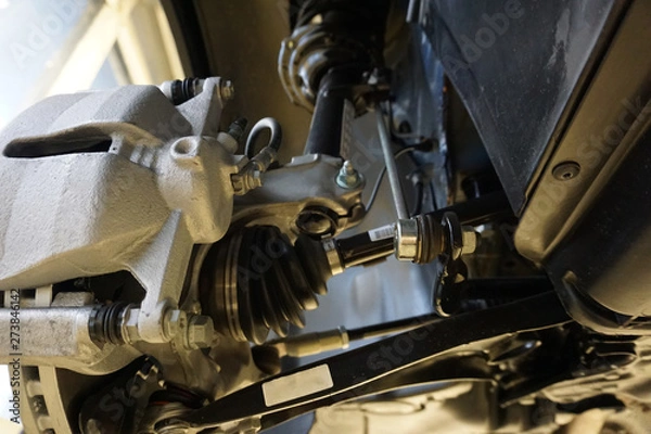 Fototapeta Sharp technical photograph.  The design and elements of a modern car. Front suspension. Shock absorber. Suspension arm of a vehicle. Drive shaft.
