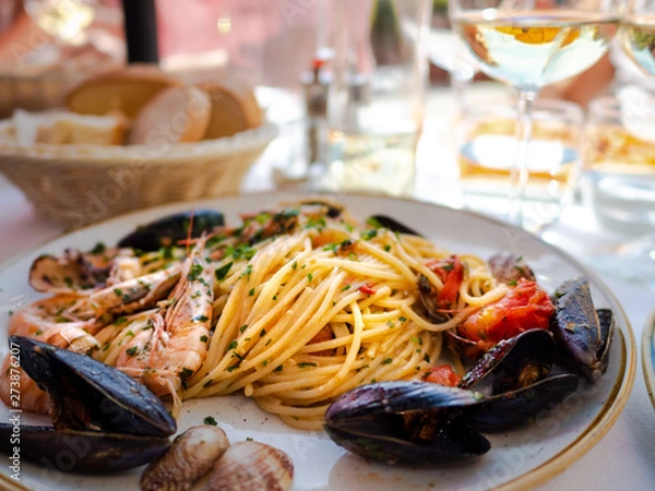 Fototapeta Spaghetti allo scoglio or spaghetti with seafood served in a white dish with shrimps