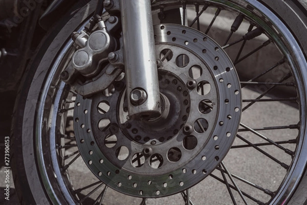 Fototapeta Motorcycle wheel with disk brakes system and metal spokes. Close up detailed photo of motorbike forks and tire. Different parts of two-wheeled vehicle. Transportation. Modern driving technologies.