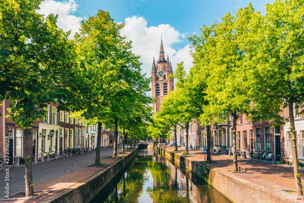 Fototapeta Canal with Leaning Church Tower in Delft Netherlands