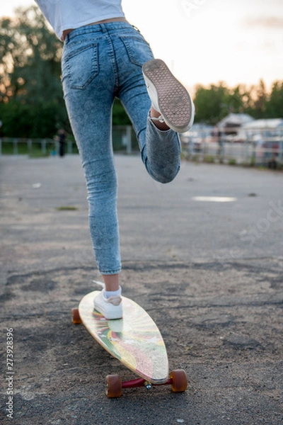 Obraz Girl with longboard wearing sneakers shoes in urban style