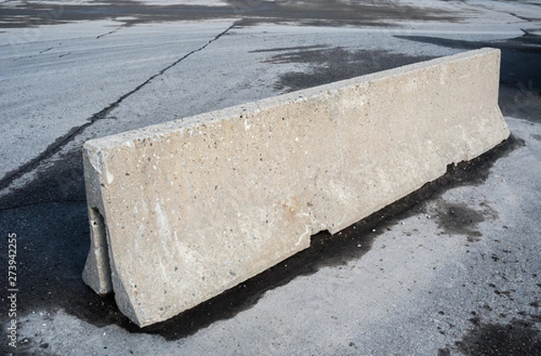 Obraz Concrete barrier on dirty asphalt.