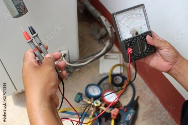 Fototapeta The technician is using tools to check the air conditioner, take a blur
