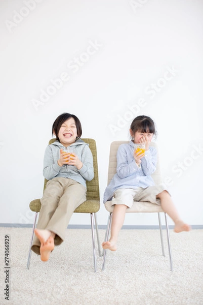 Fototapeta 椅子に座りジュースを飲む子供
