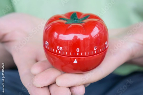 Fototapeta Red tomato kitchen timer set to 0, held by both hands, with open palms