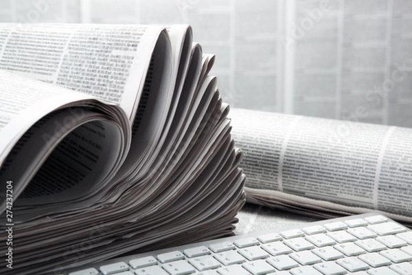 Obraz keyboard pc and piles of numerous printed newspapers