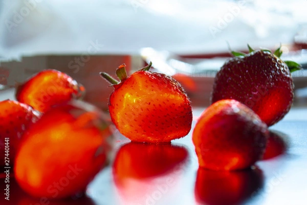 Obraz Ripe strawberries with leaves in wicker basket on table on blurred background