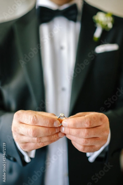 Obraz engagement ring in the hands of the groom