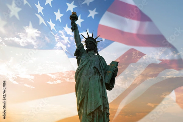 Fototapeta Double exposure with statue of liberty and United States flag blowing in the wind.