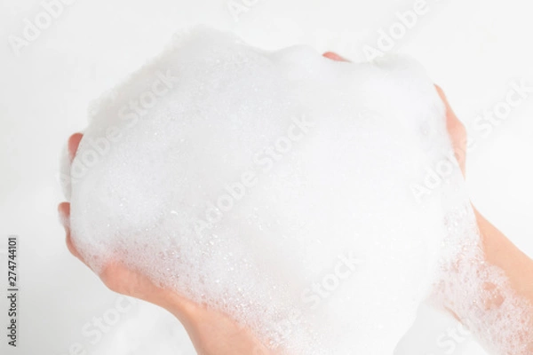 Fototapeta A lot of foam in the hands of a man in the bathroom