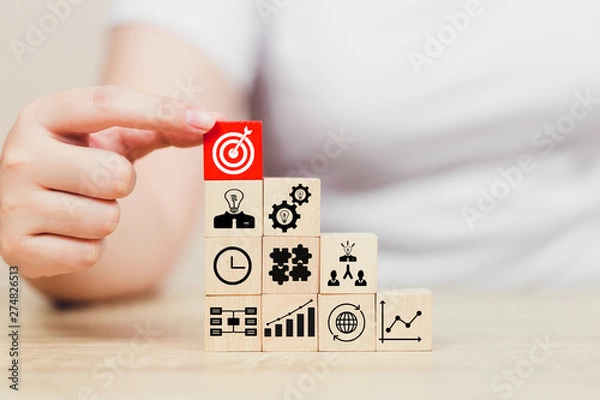 Fototapeta Hand of busines hold a target with arrow,stacking wooden blocks into steps,Concept of business growth success