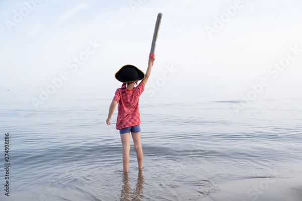 Obraz pirate child looks out to sea and shakes his sword up high