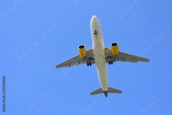 Fototapeta Airplane in flight with the blue sky at the background