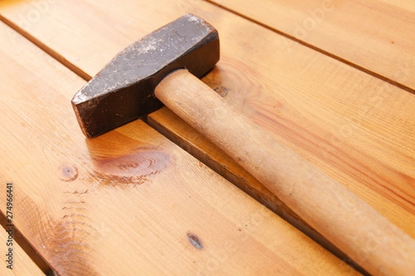 Obraz A black mallet is laying on a wooden surface