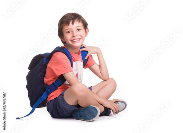Obraz Happy smiling school boy siitting on the floor, isolated on a white background